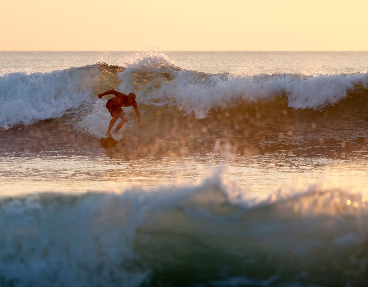 man-surfing-in-bali-indonesia-kuta-beach-at-suns-2021-09-01-00-39-16-utc