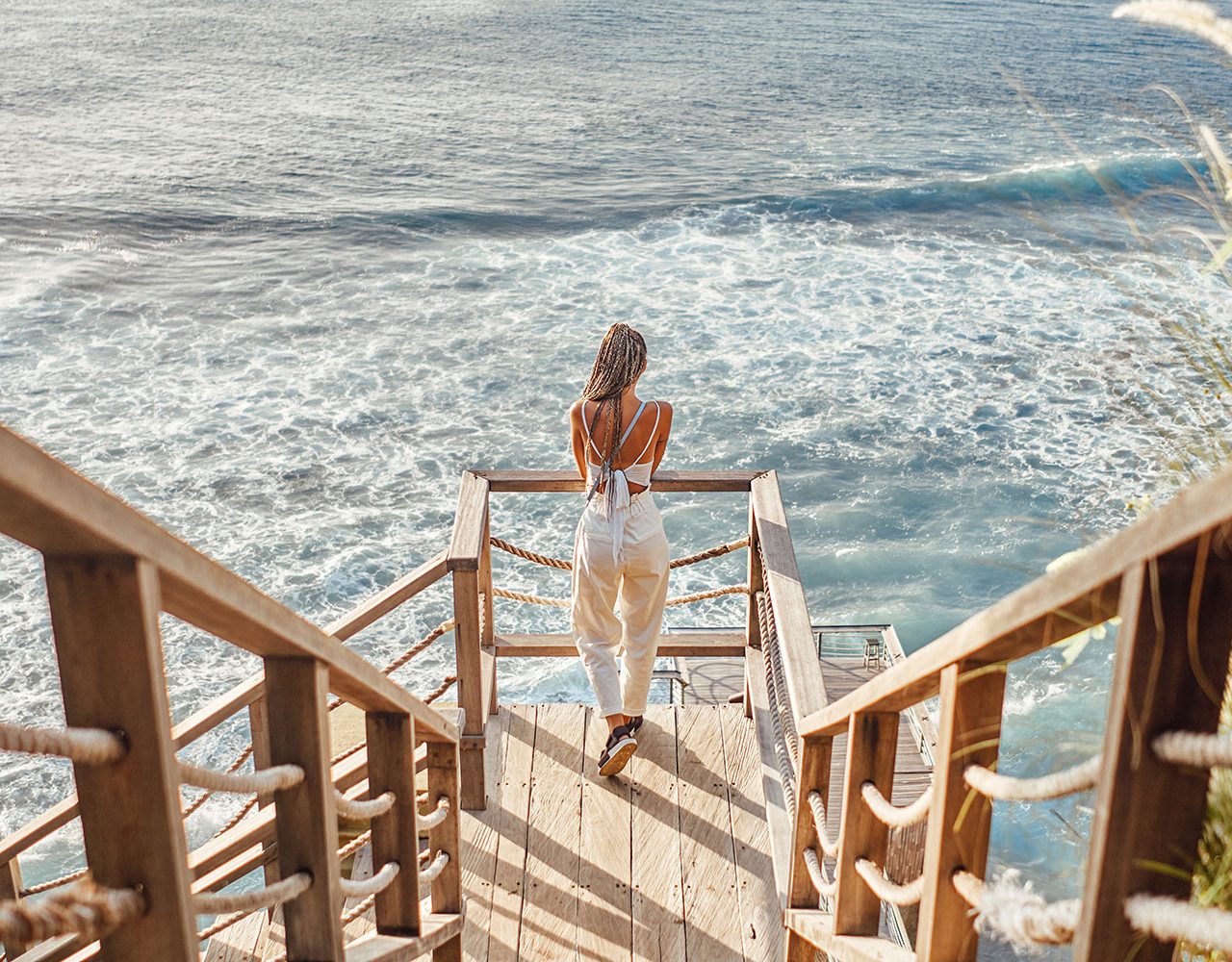 woman-with-dreadlocks-looking-at-sea-waves-in-bali-2021-09-04-14-56-19-utc